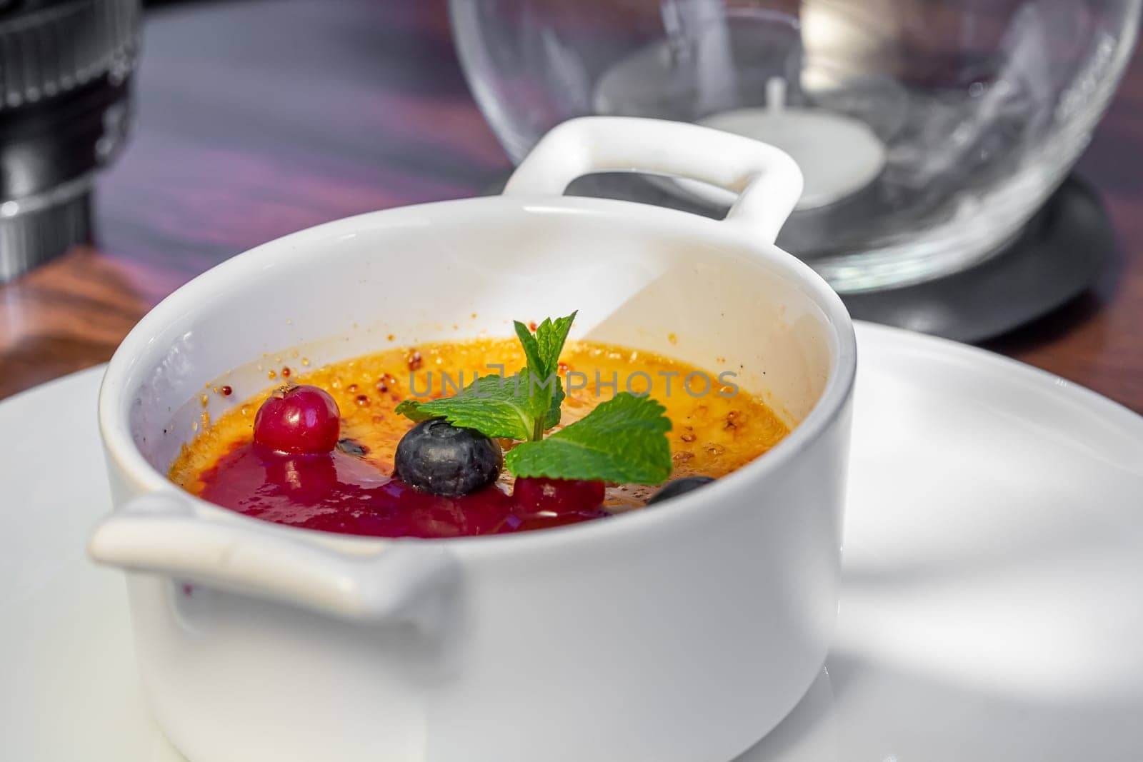 Dessert creme brulee or Catalan cream with mint leaves and berries.