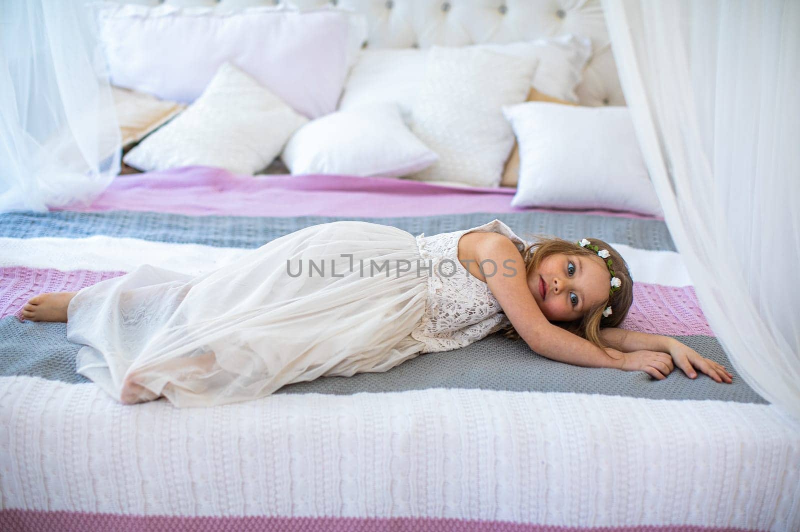 Beautiful girl in white dress standing on bed by nasdushka