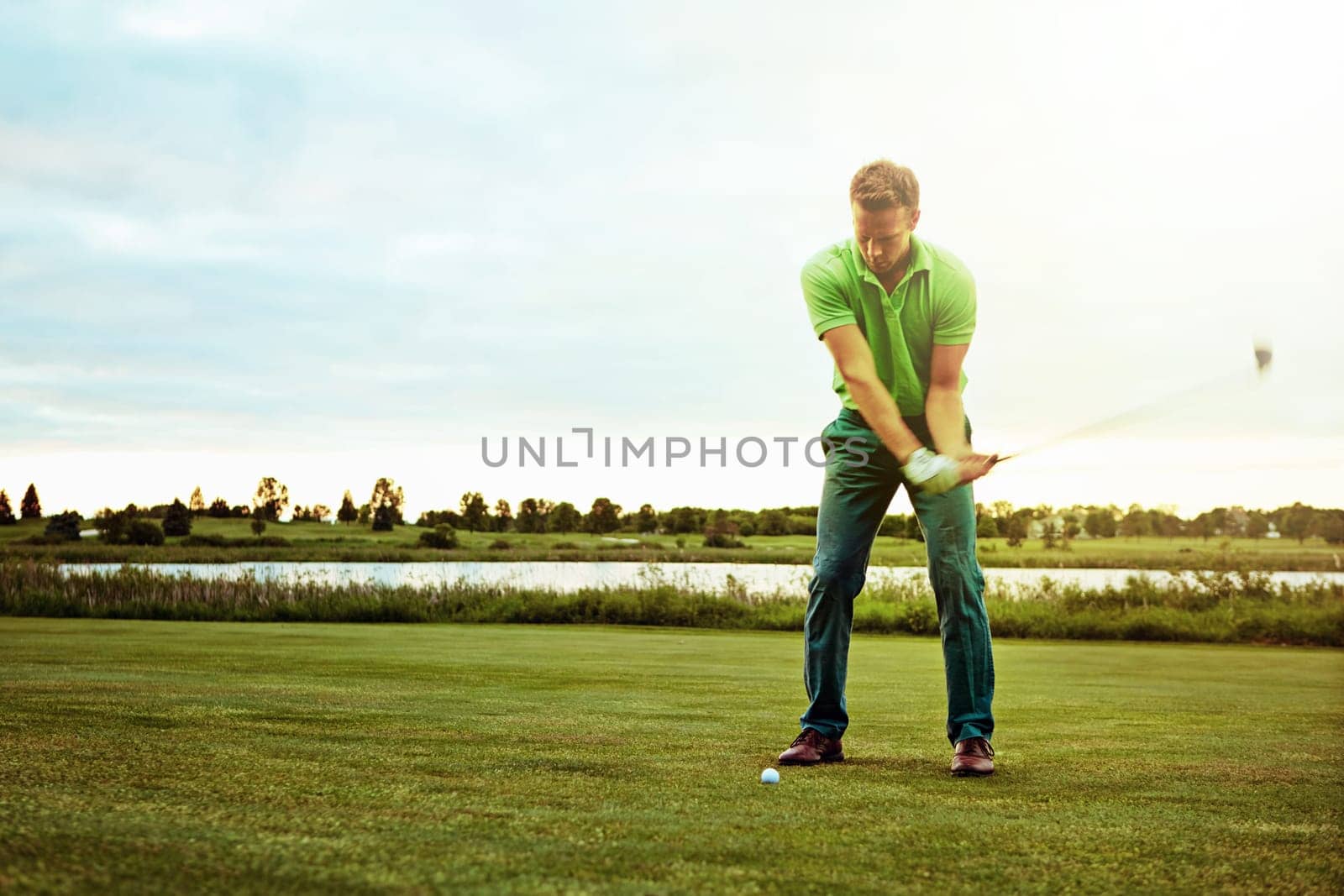 Playing golf and playing it well. a man practicing his swing on the golf course. by YuriArcurs