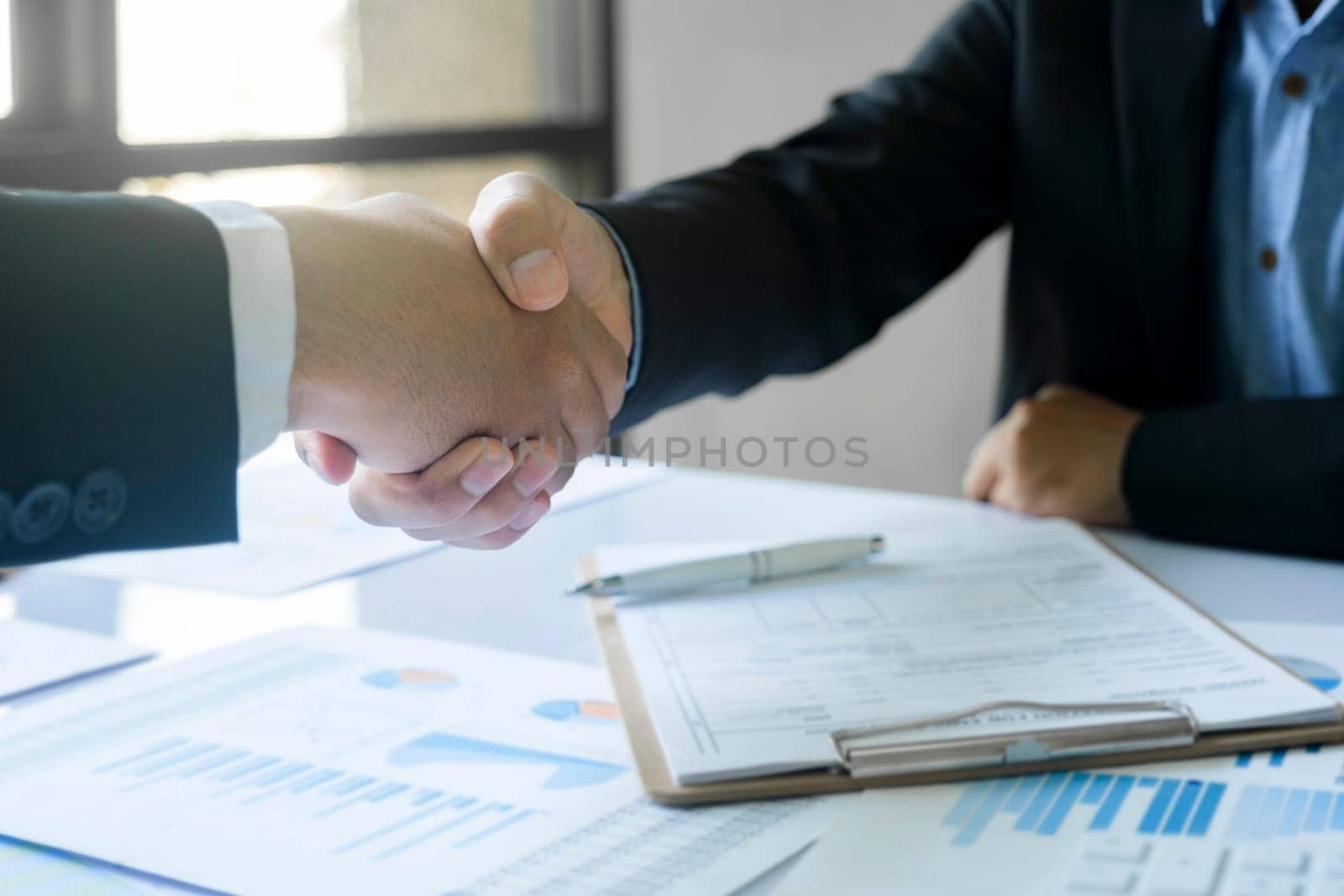 The businessman and his partnership are agree with their concept. The image of two businessman are shaking hands together. The successful persons are shaking hands after have a good deal with their meeting.