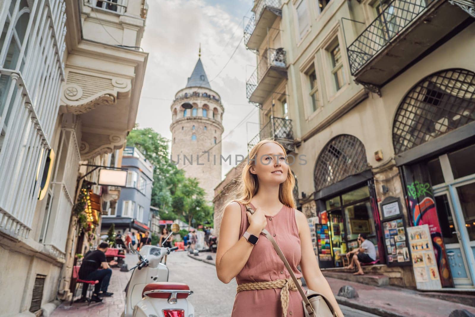 Portrait of beautiful woman tourist with view of Galata tower in Beyoglu, Istanbul, Turkey. Turkiye.