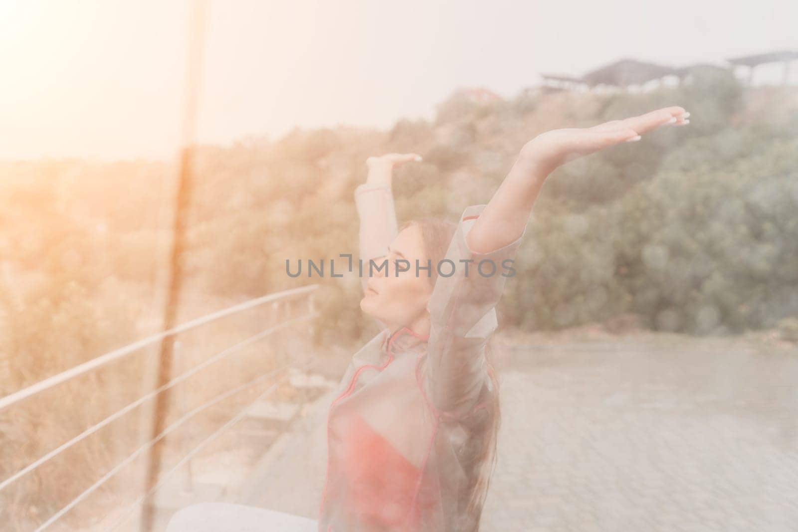 Woman rain umbrella. Happy woman portrait wearing a raincoat with transparent umbrella outdoors on rainy day in park near sea. Girl on the nature on rainy overcast day. by panophotograph