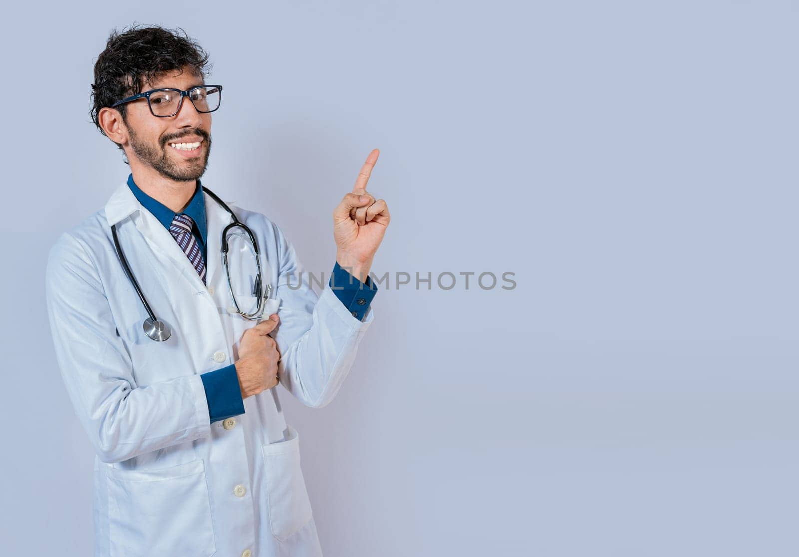 Happy bearded doctor pointing at advertising space isolated. Beard doctor pointing a promotion with finger isolated