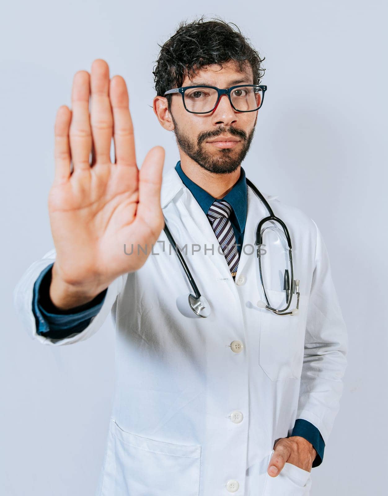 Doctor making stop with a hand isolated. Young doctor making stop with the palm of the hand by isaiphoto