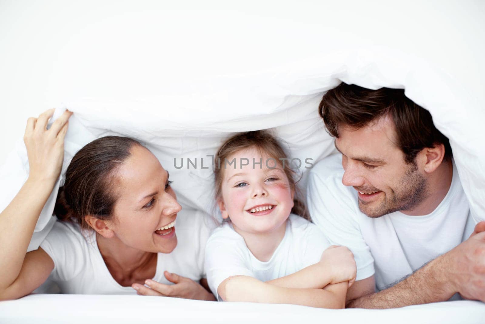 A family fort. A young family plying under neath the bedsheets. by YuriArcurs
