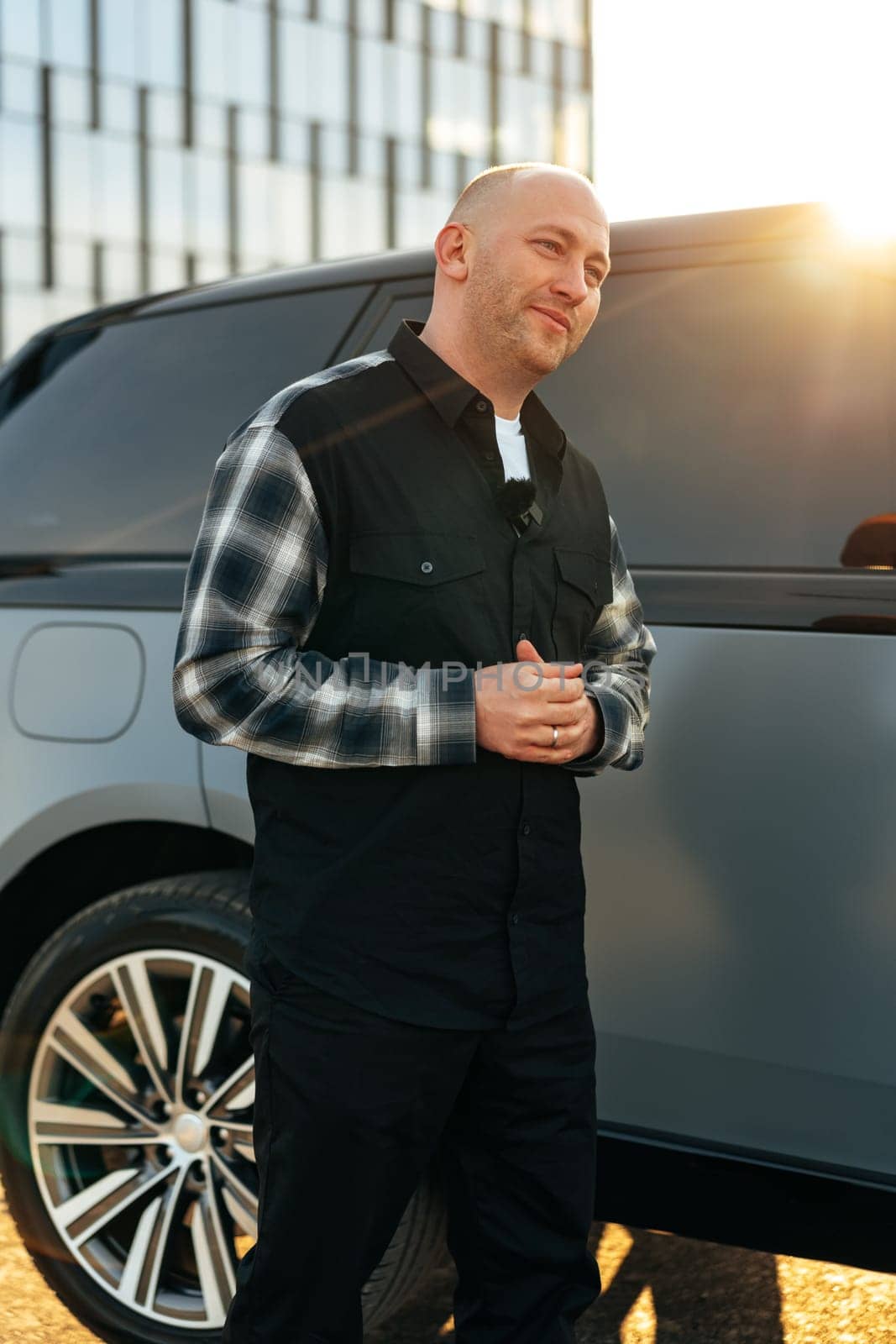 Casual man standing near his luxury car at the parking close up