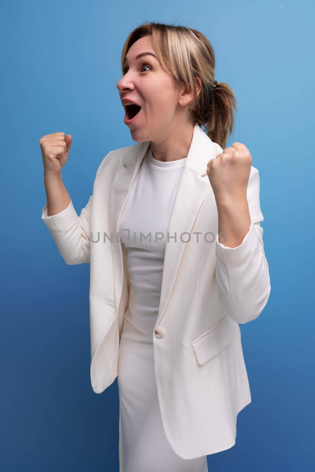 joyful happy young european woman dressed in white jacket and dress.