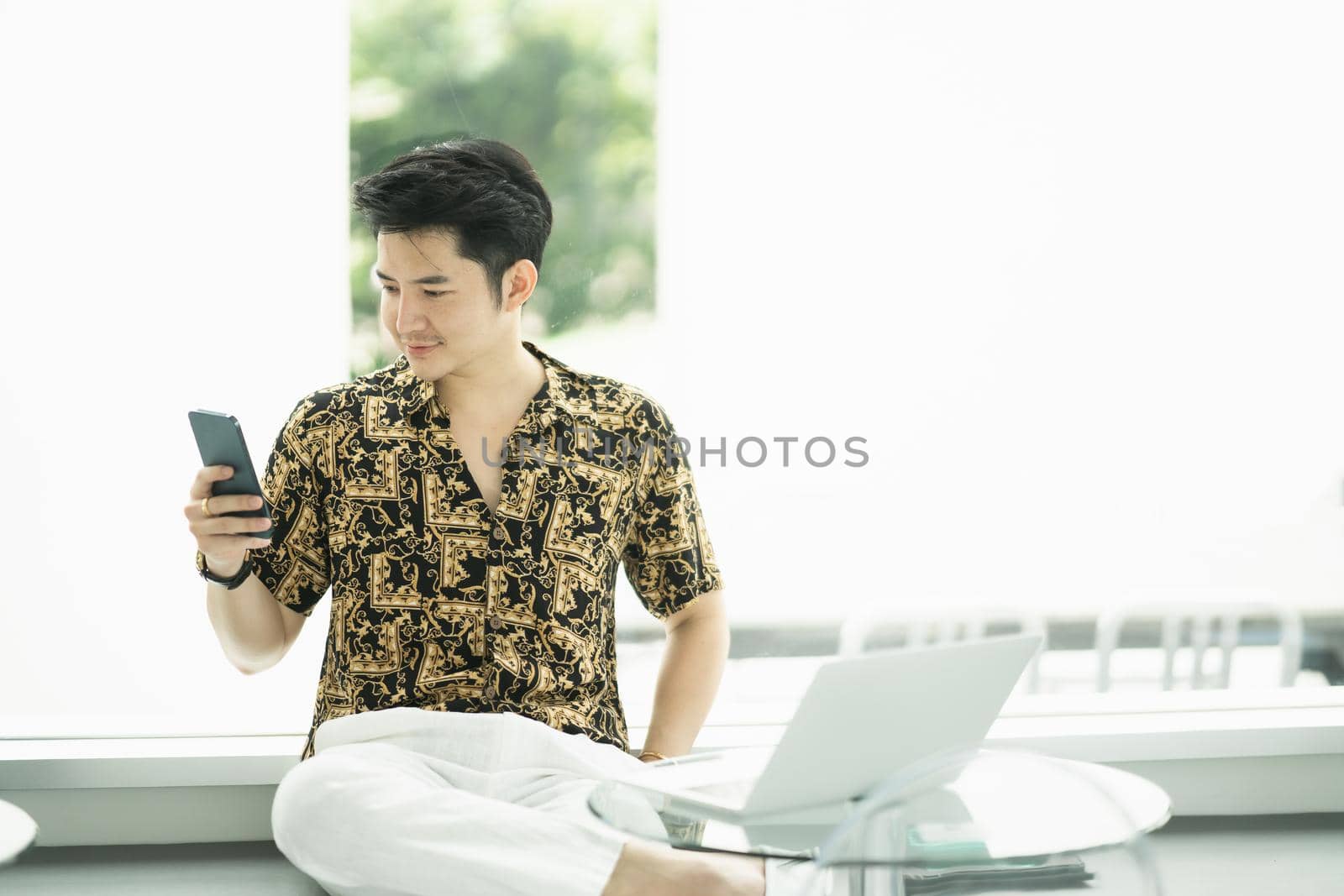 rich man using mobile phone and working with laptop at the cafe