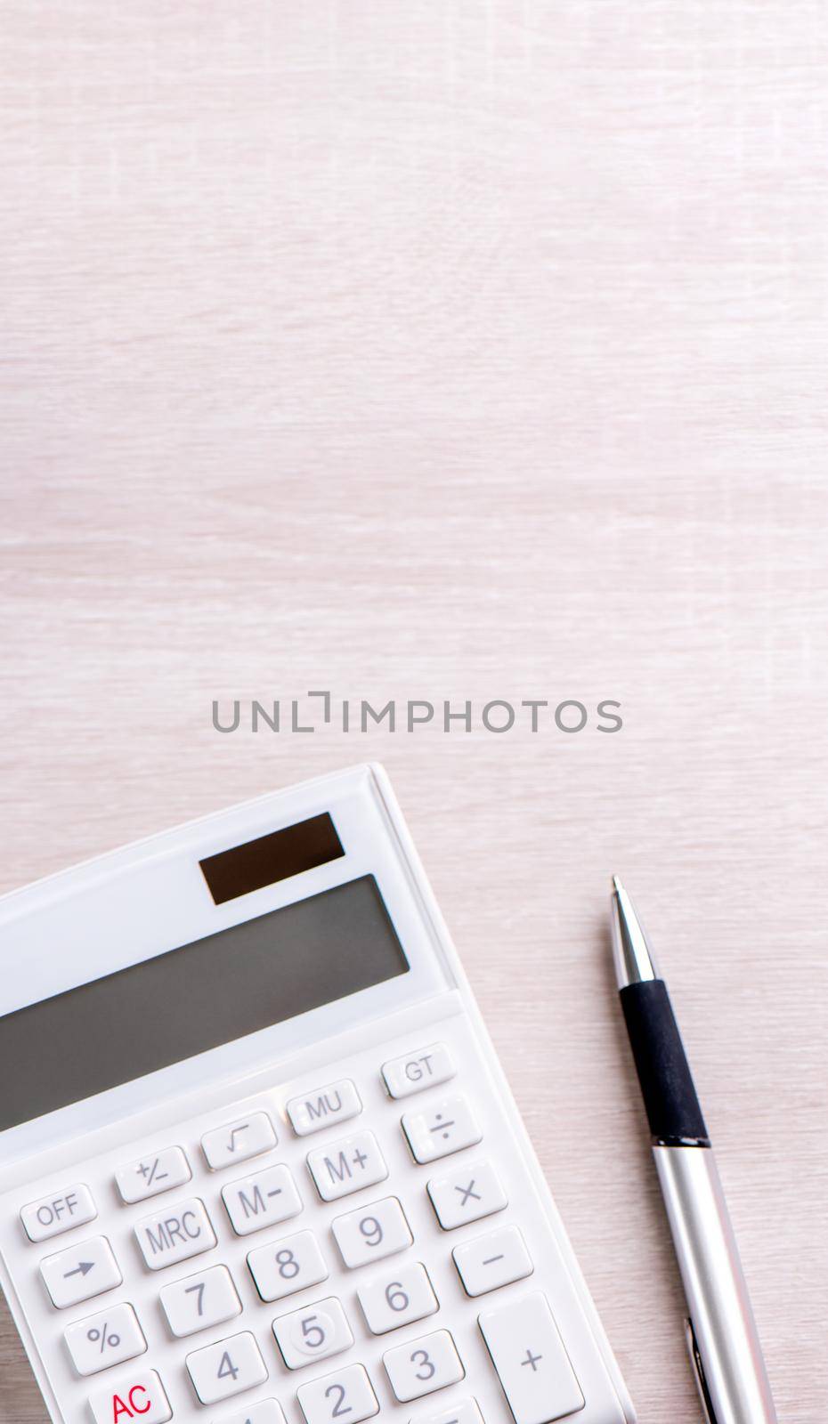 White calculator and pen on bright wooden table, analytics and statistics of financial profit, investment risk concept, copy space, top view flat lay