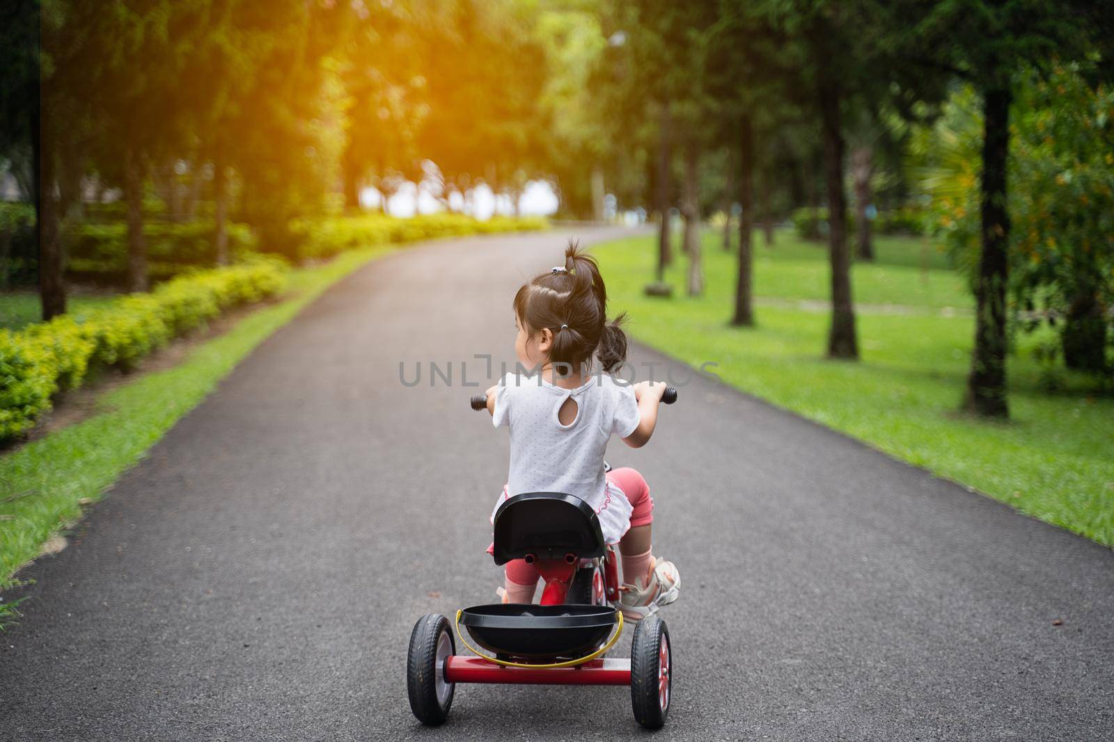 cute baby riding bicycle in the garden