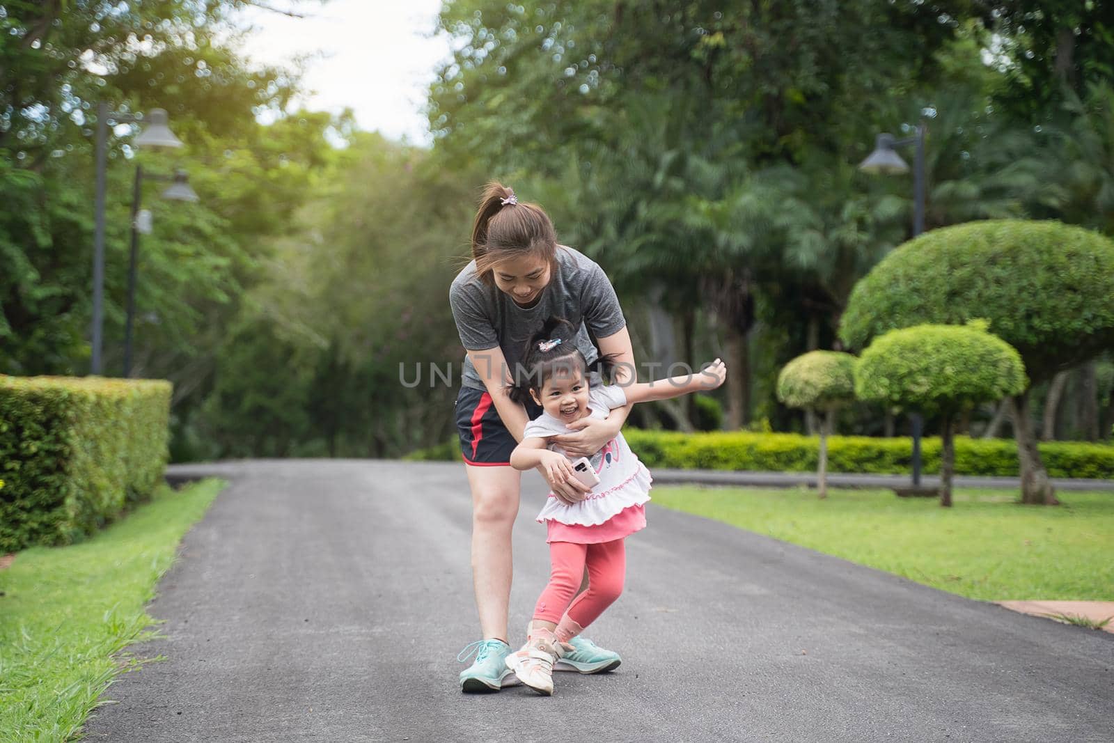 cute baby running with her mother in the garden, family happy concept