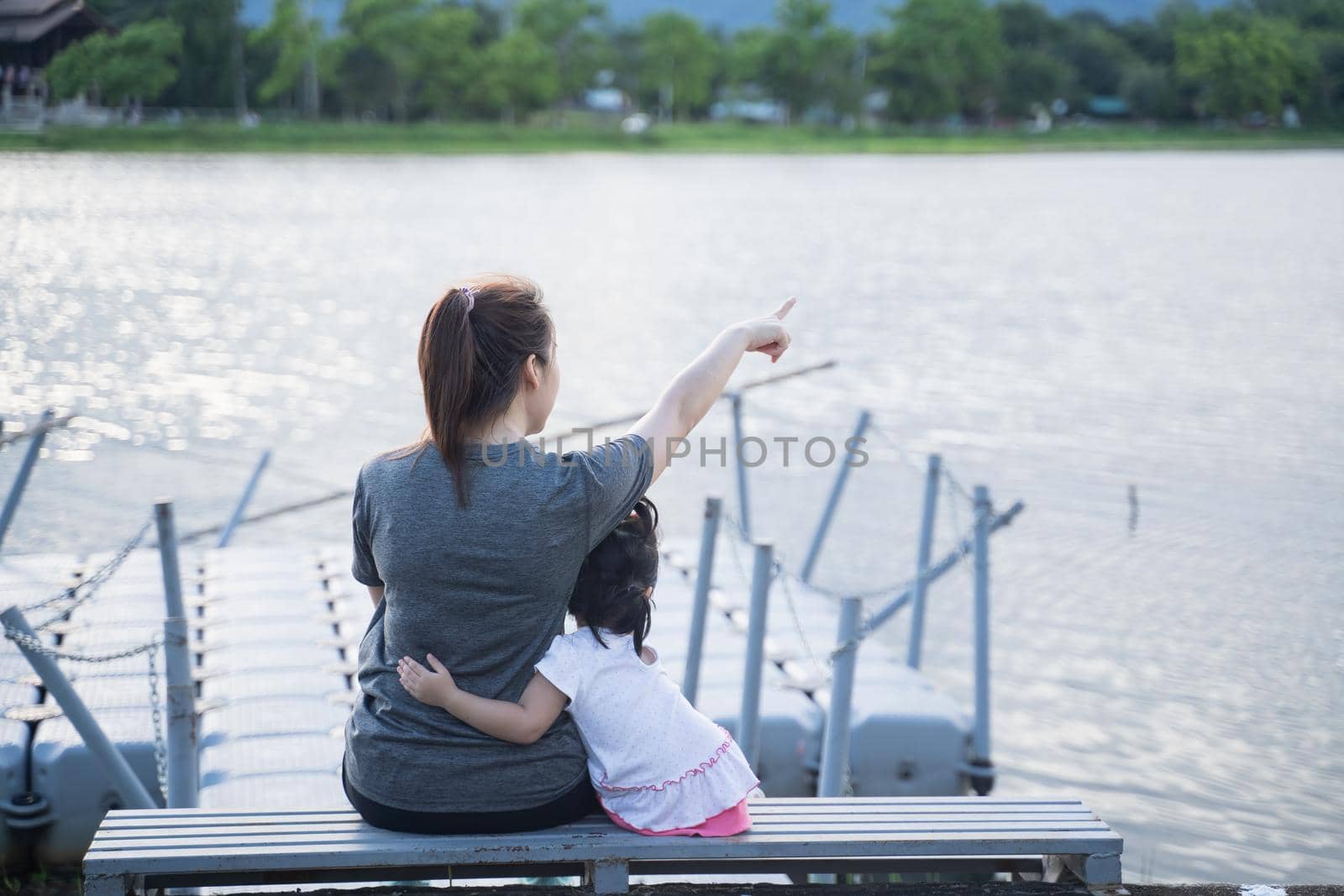 mother and her daughter sitting and looking to the river