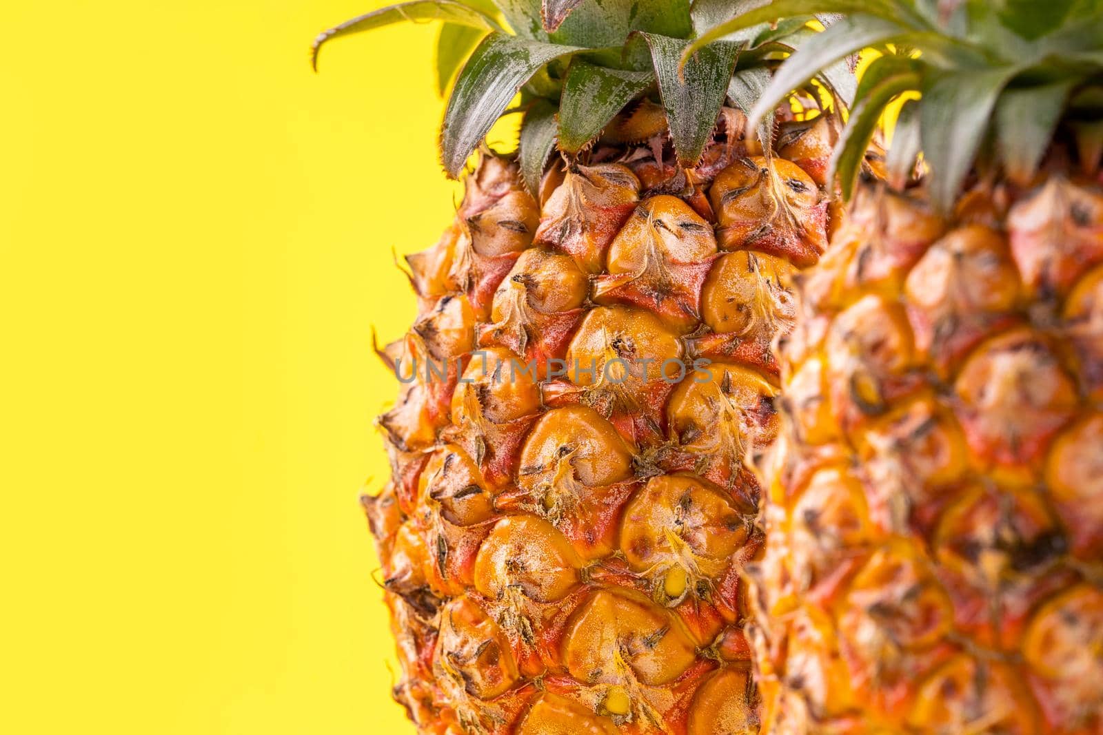 Beautiful fresh pineapple isolated on bright yellow background, summer seasonal fruit design idea pattern concept, copy space, close up