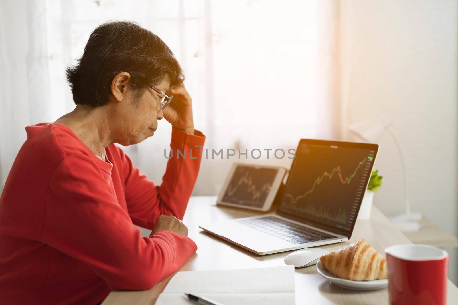 Senior woman depression and serious about checking Bitcoin price chart on digital exchange on laptop by Wmpix