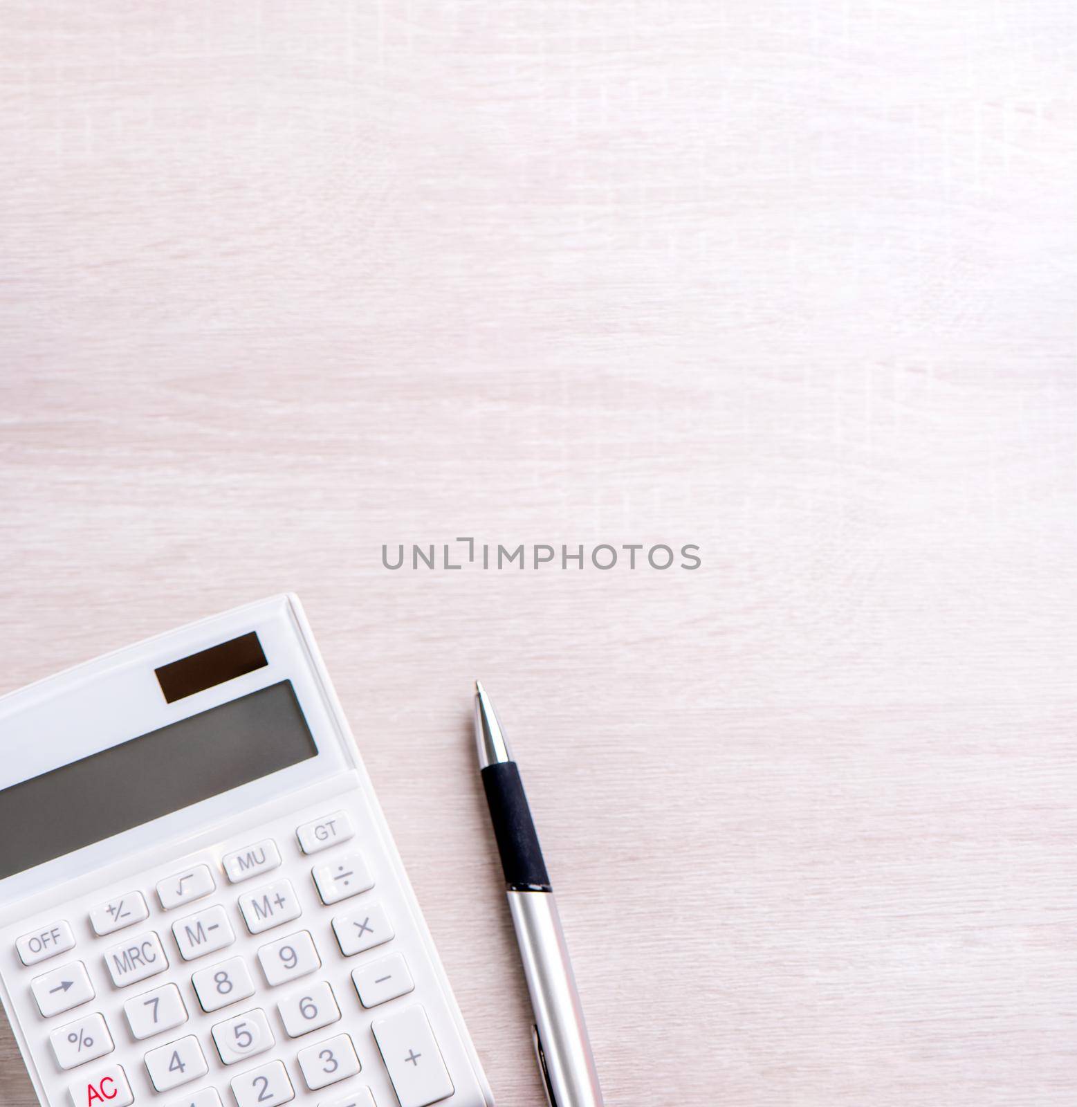 White calculator and pen on bright wooden table, analytics and statistics of financial profit, investment risk concept, copy space, top view flat lay