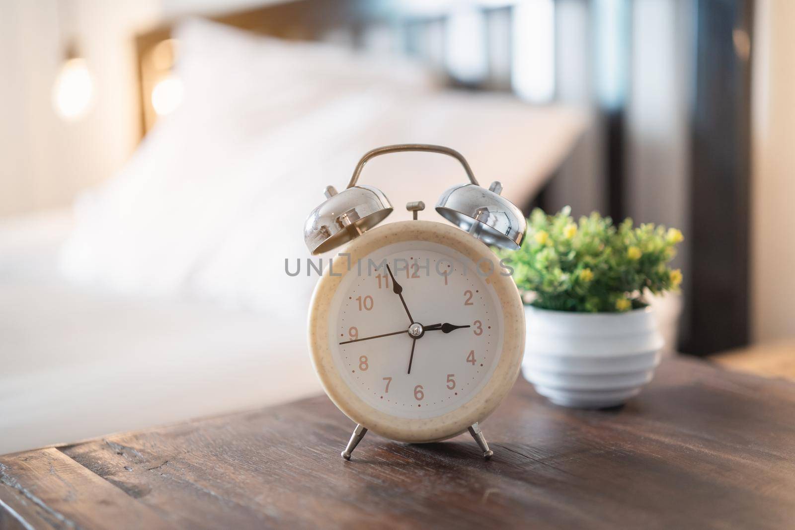 alarm clock on the table in the bedroom at home by Wmpix