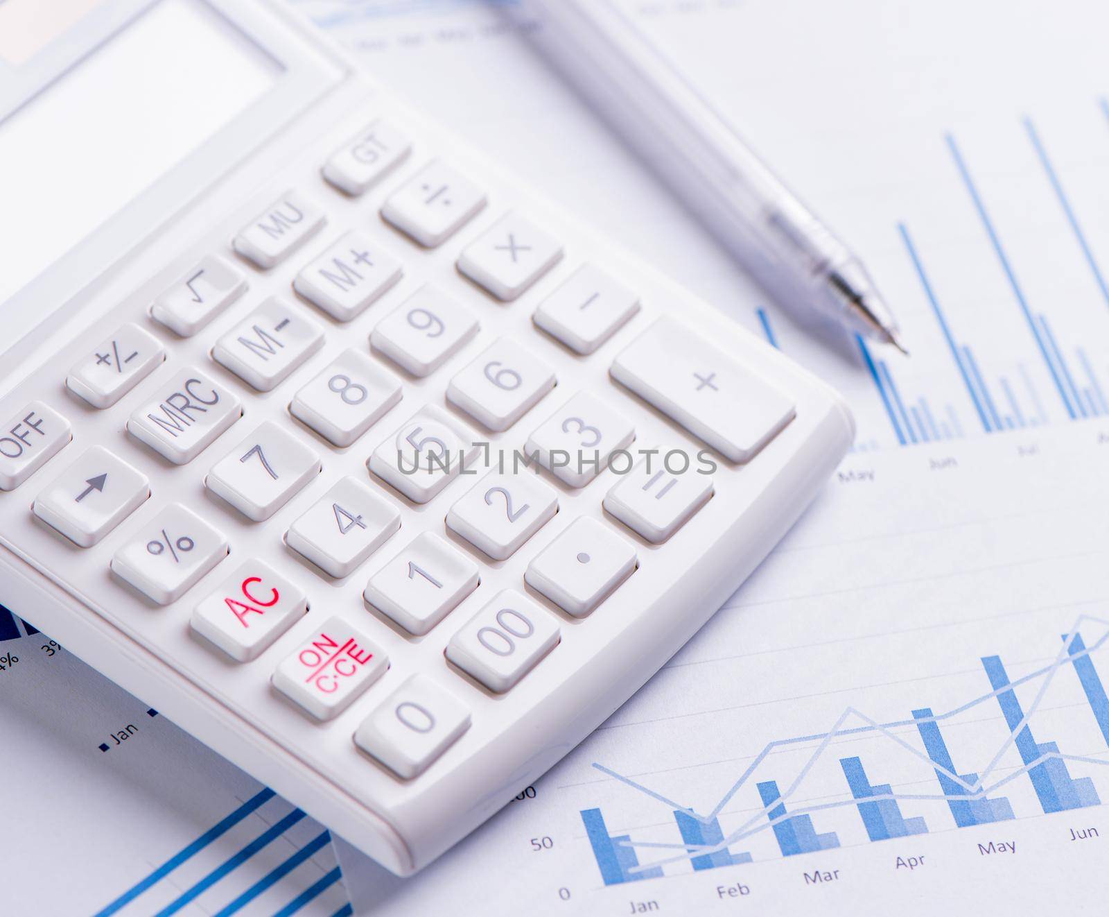 White calculator and report with chart and graph, concept of annual financial profit overview, banking and investment, close up, copy space, macro