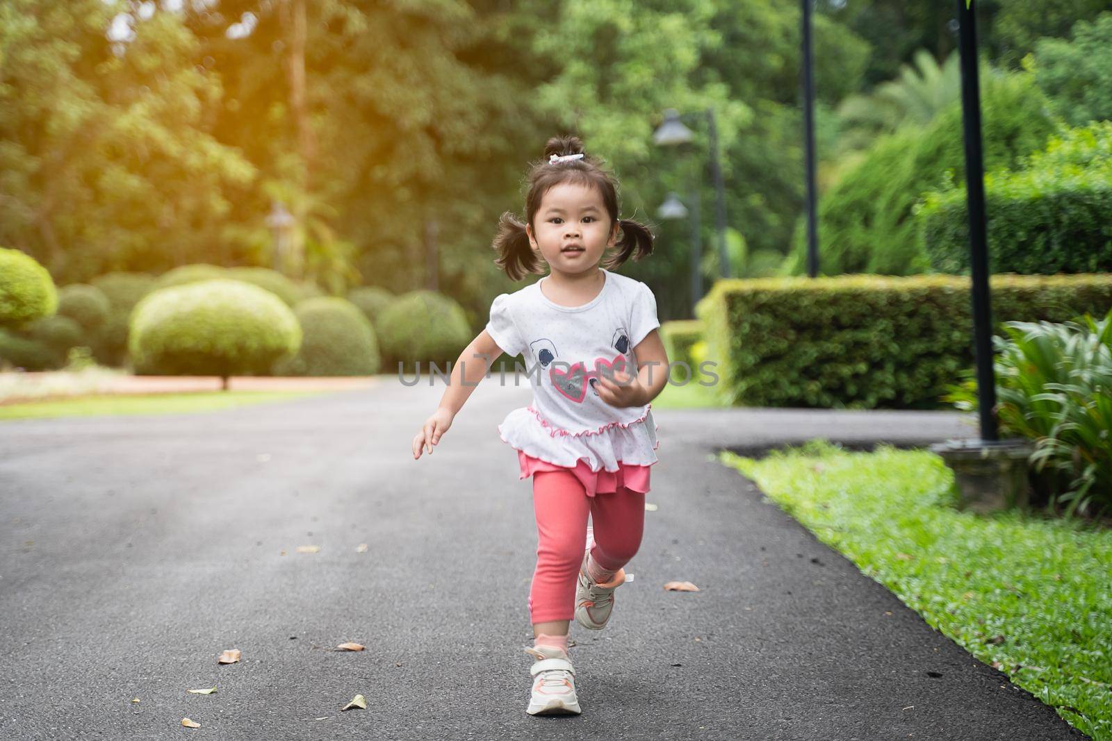 cute girl running at the garden