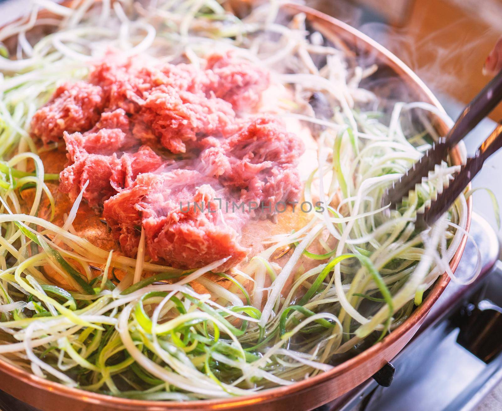 Beef barbecue bulgogi in South Korea restaurant in Seoul, lifestyle fresh korean food cuisine on copper pan with sliced grill, close up, copy space