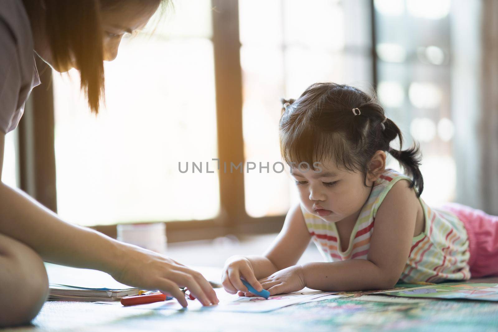 cute baby girl painting with her mother at the house