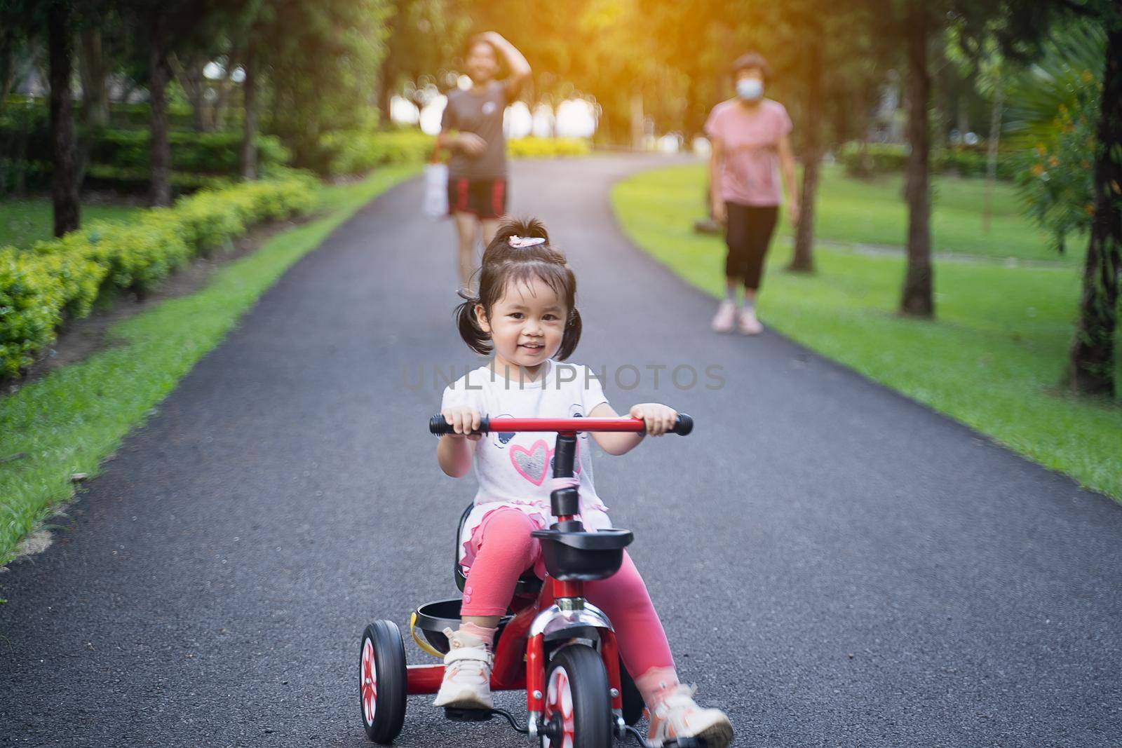 Cute children riding a bike. Kids enjoying a bicycle ride. by Wmpix