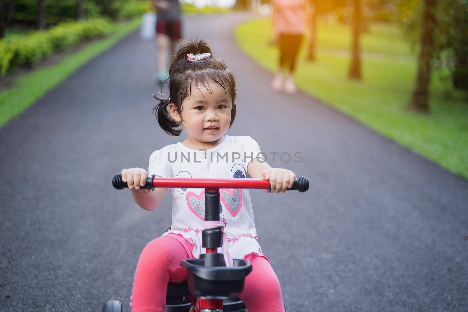 Cute children riding a bike. Kids enjoying a bicycle ride.