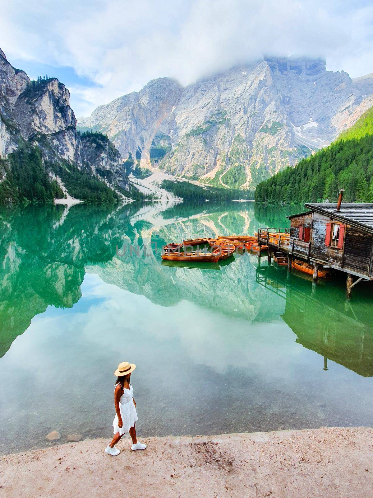 woman on vacation in the Italian Dolomites, Beautiful lake in the Italian Alps, Lago di Braies. 