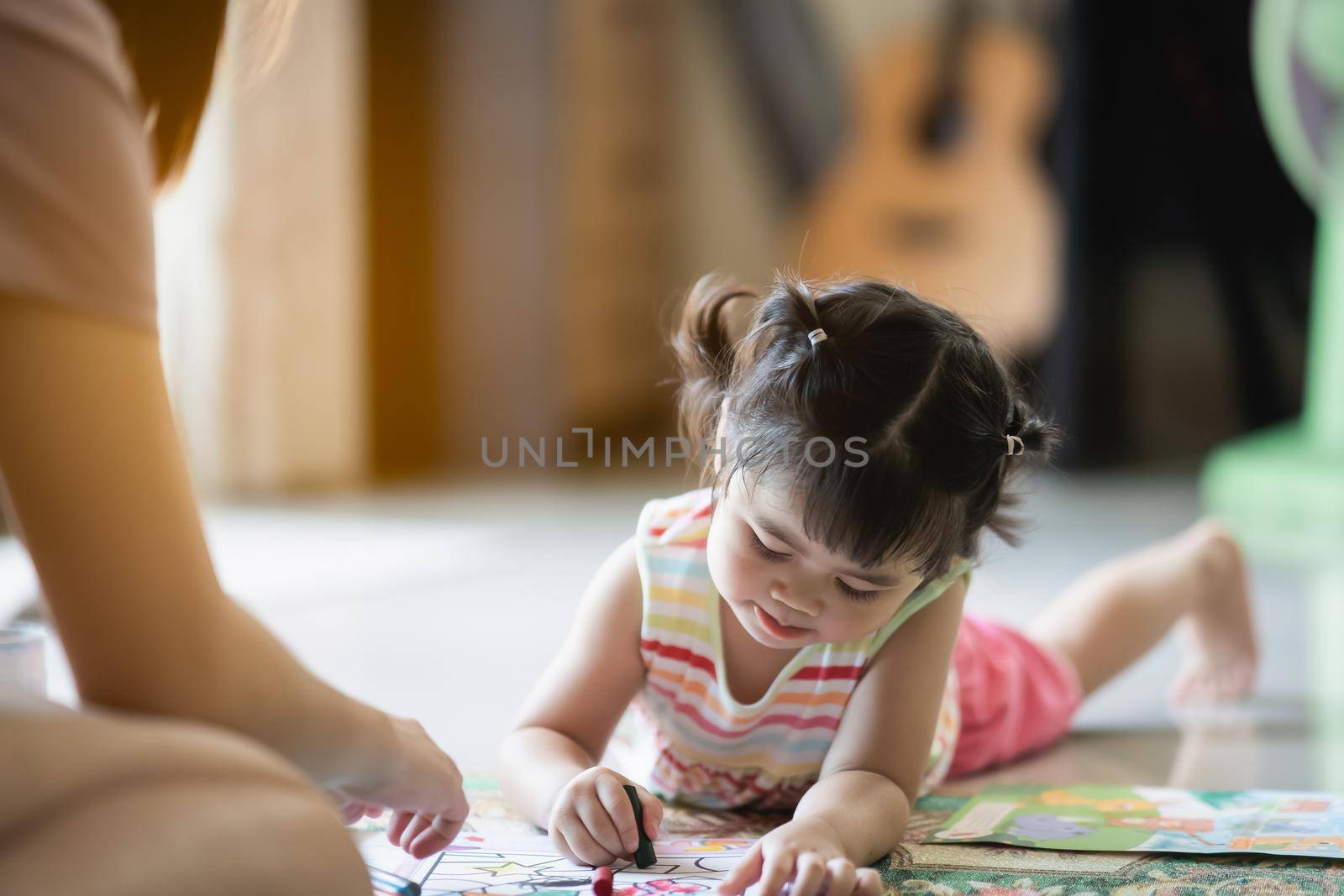 cute baby girl painting with her mother at the house by Wmpix