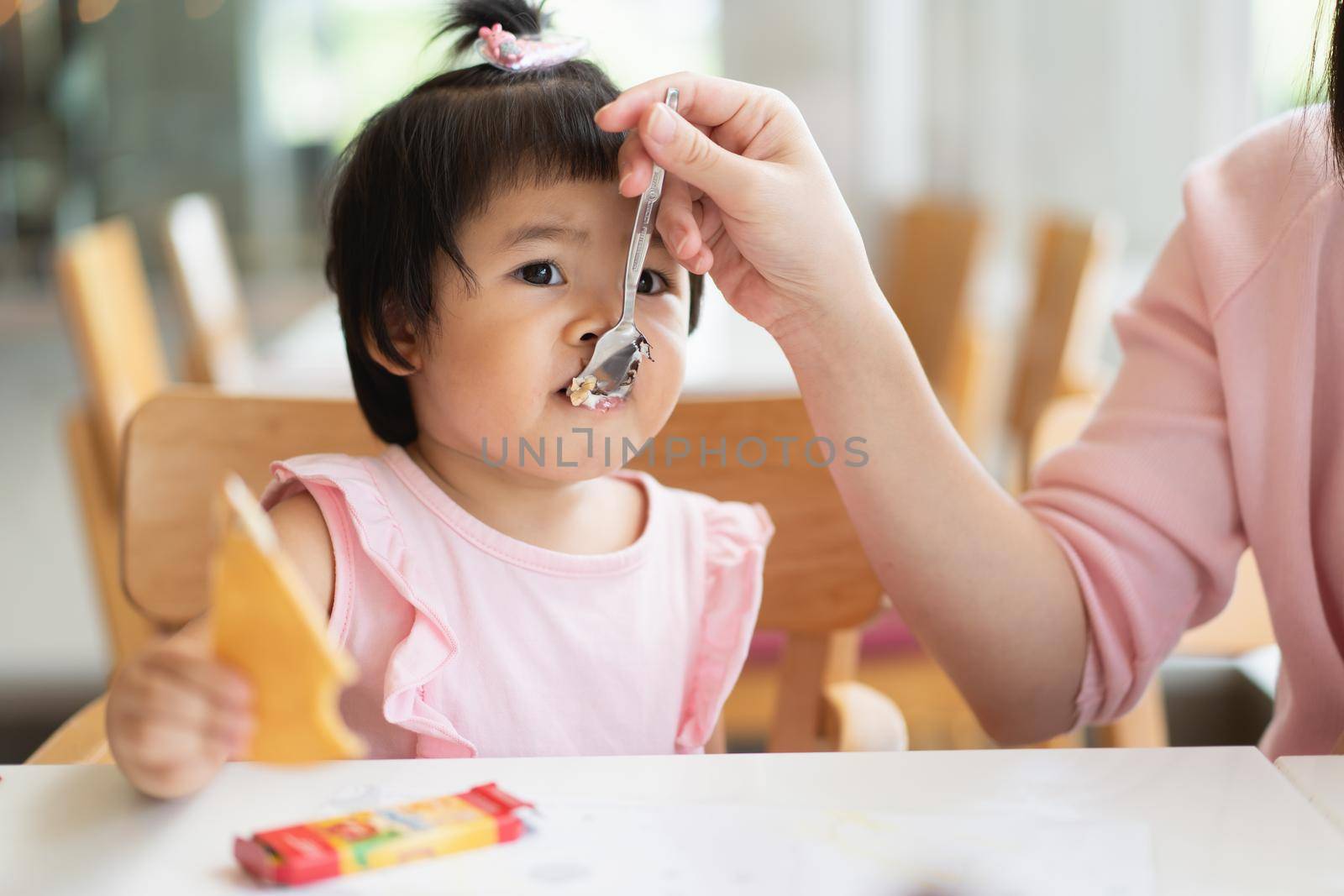 cute baby eating ice cream on the table in the restaurant