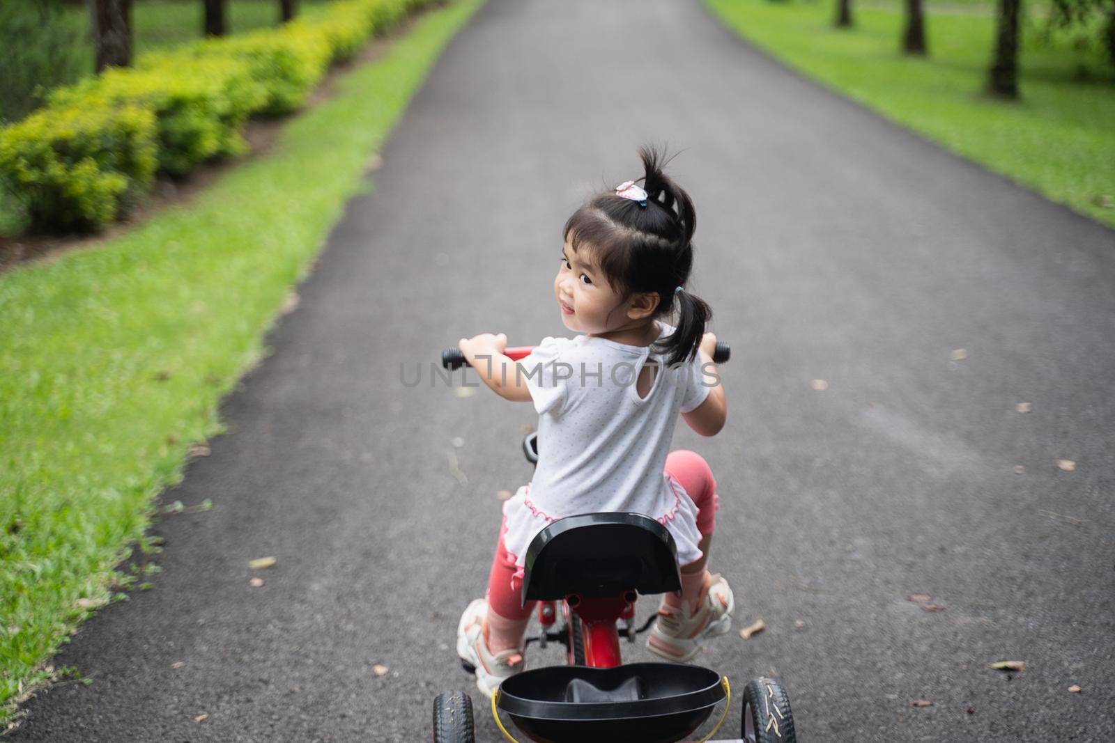 cute baby riding bicycle in the garden