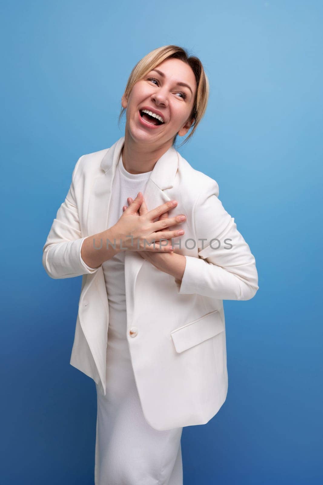 friendly young european woman in white jacket and dress.