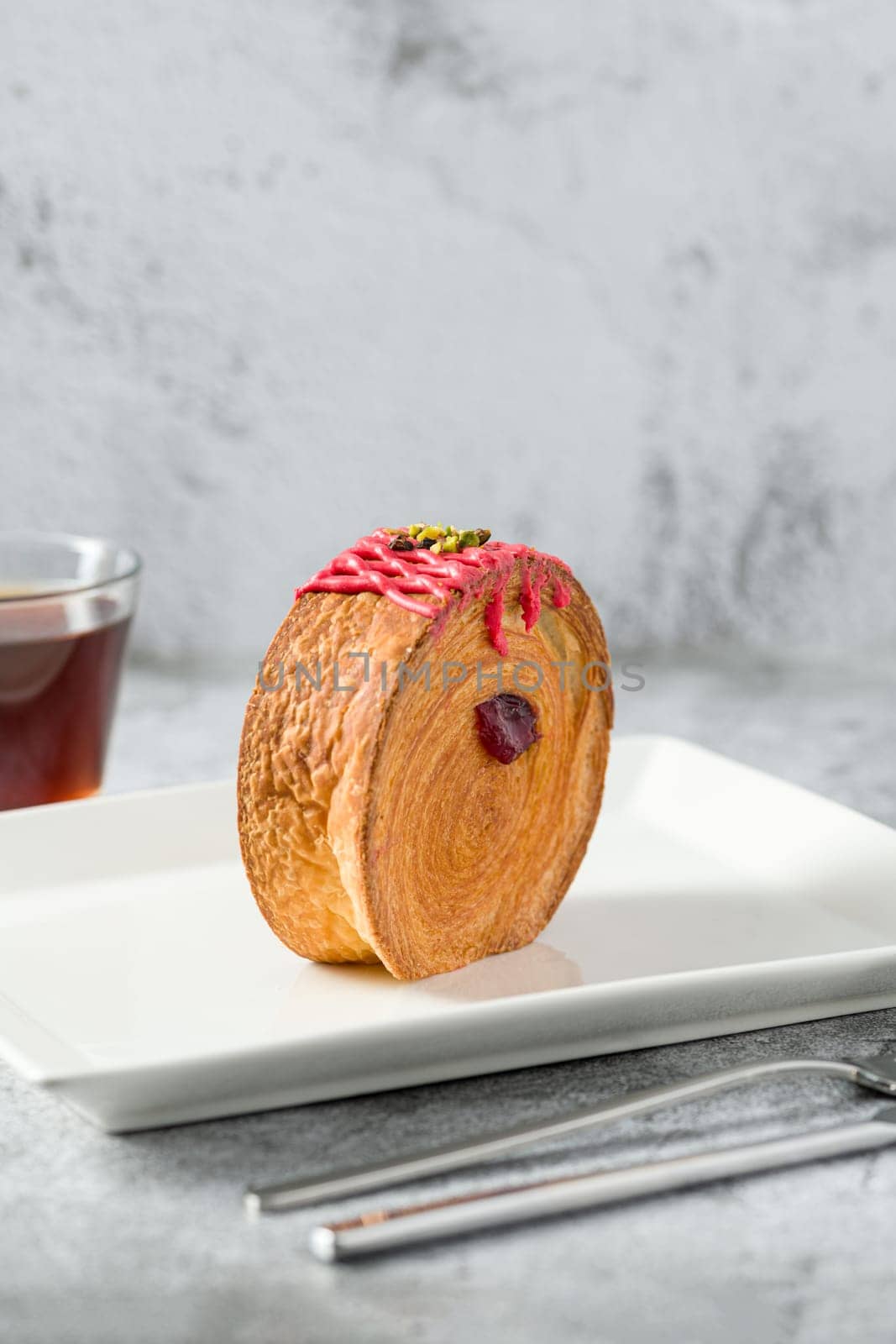 New York roll or round croissant with marmalade with tea on stone table by Sonat
