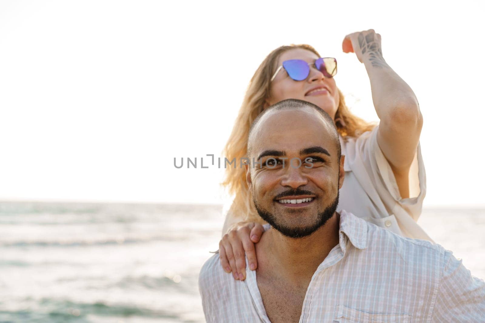 Young happy couple on seashore enjoying the sea, close up