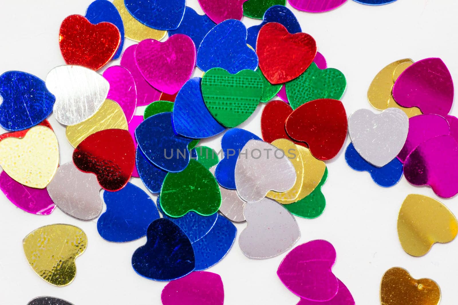 Color shiny hearts on the table for Valentine's Day. Isolated over white background