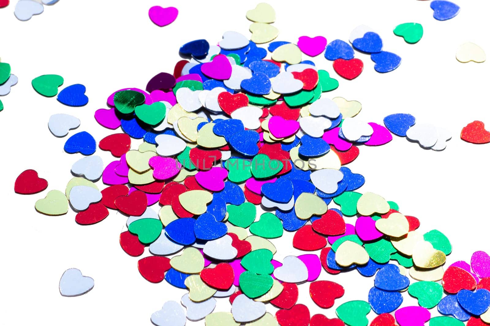Color shiny hearts on the table for Valentine's Day. Isolated over white background
