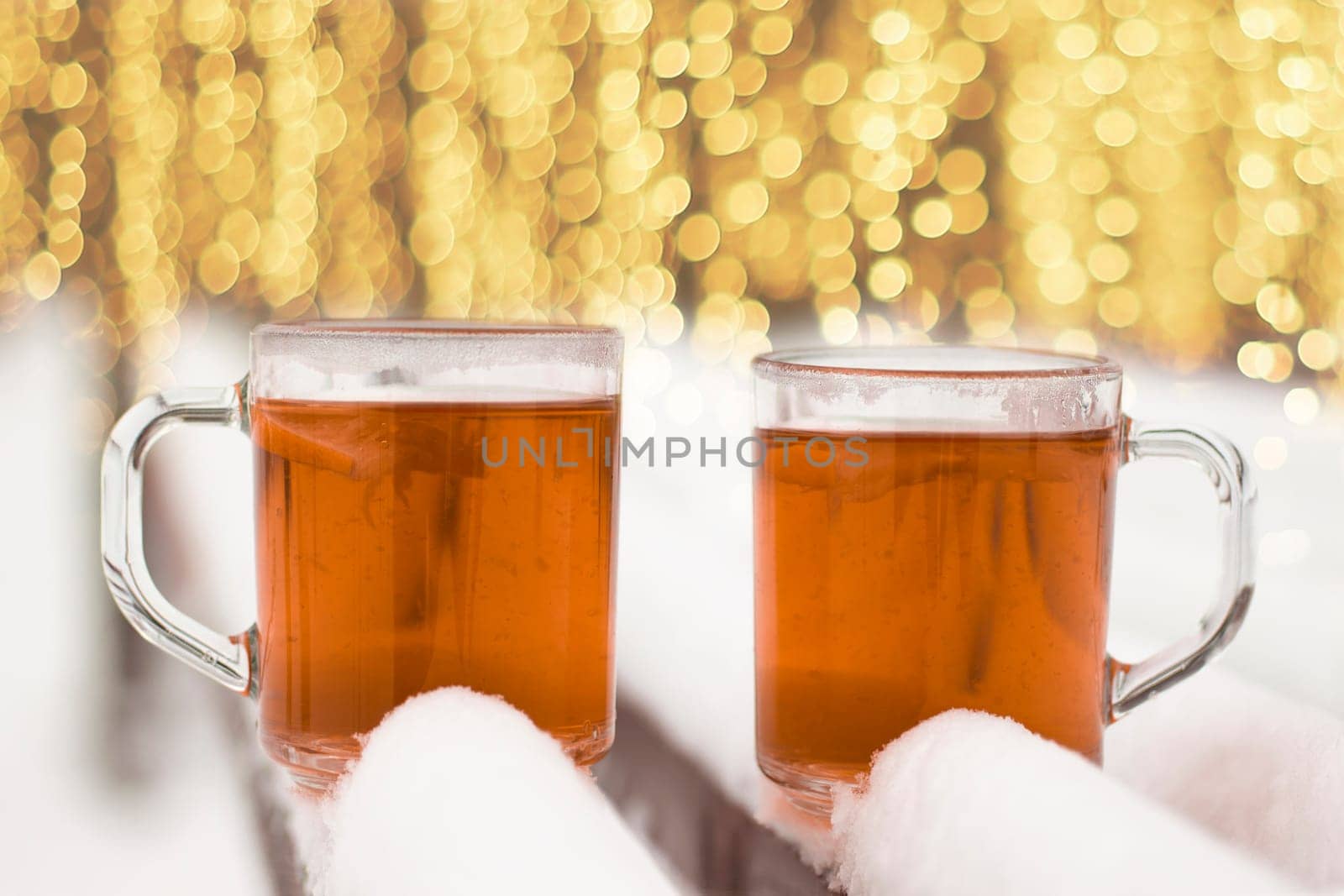 Two cups with hot tea on a  snow background