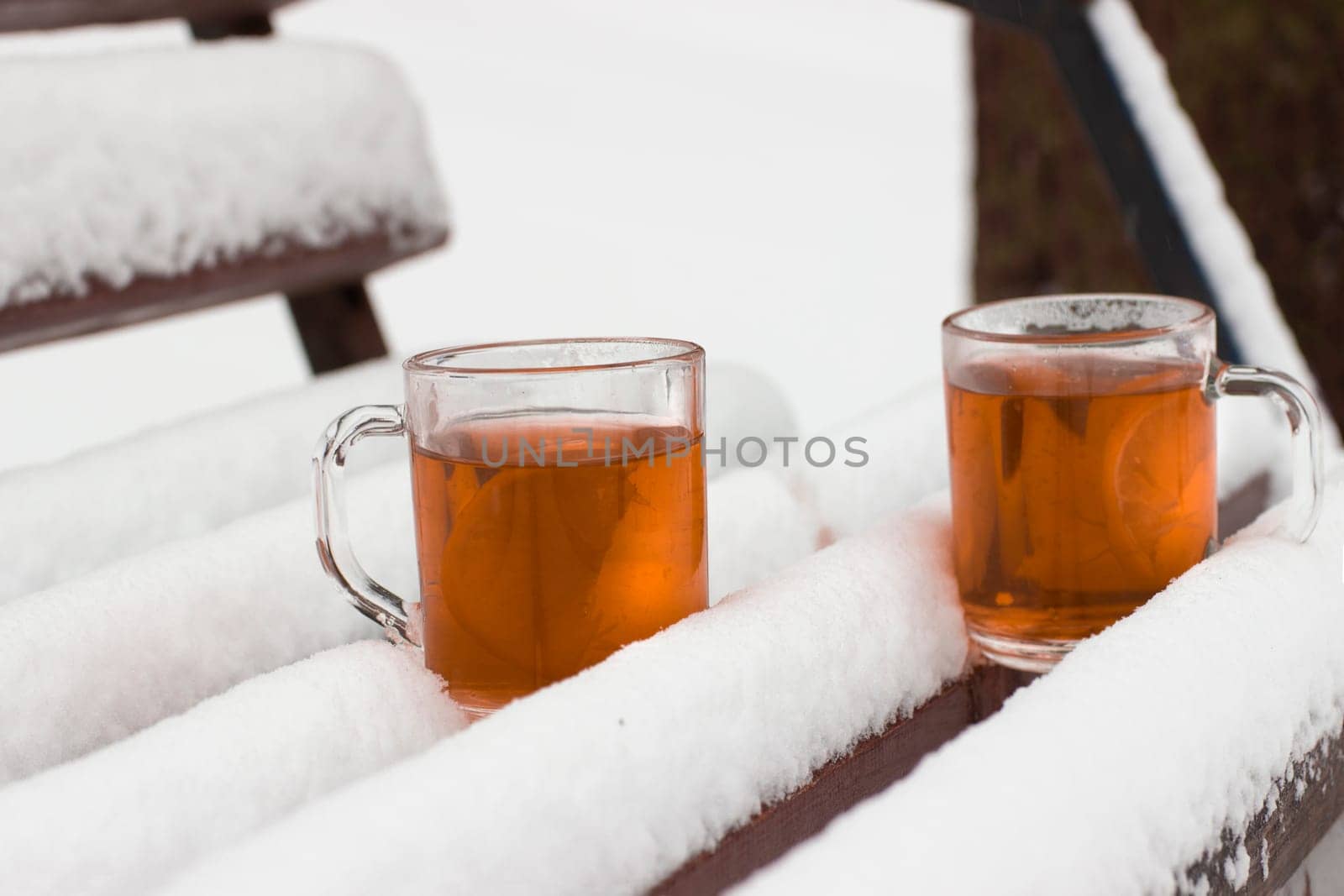 Two cups with hot tea on a  snow background
