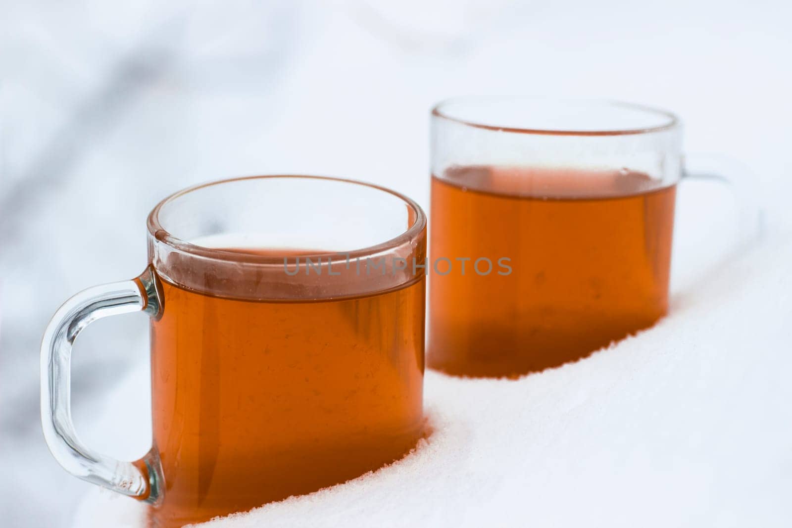 Two cups with hot tea on a  snow background