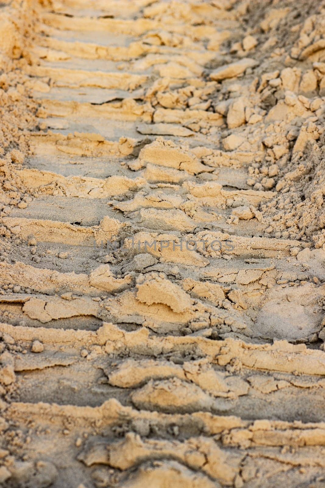 Trail from the tractor in the sand ground on the nature outdoors. Texture, background, sample