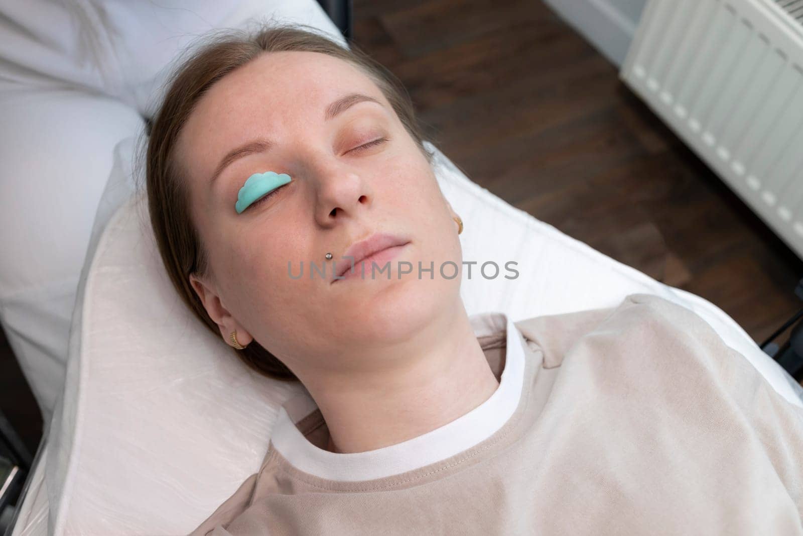 Topview Eyelash Care Treatment Procedures: Laminating, Curling, Staining, Extension For Lashes. Young Woman Lying On Couch Under Process Of Lash Lift, Nourishing Treatment With Keratin. Horizontal.