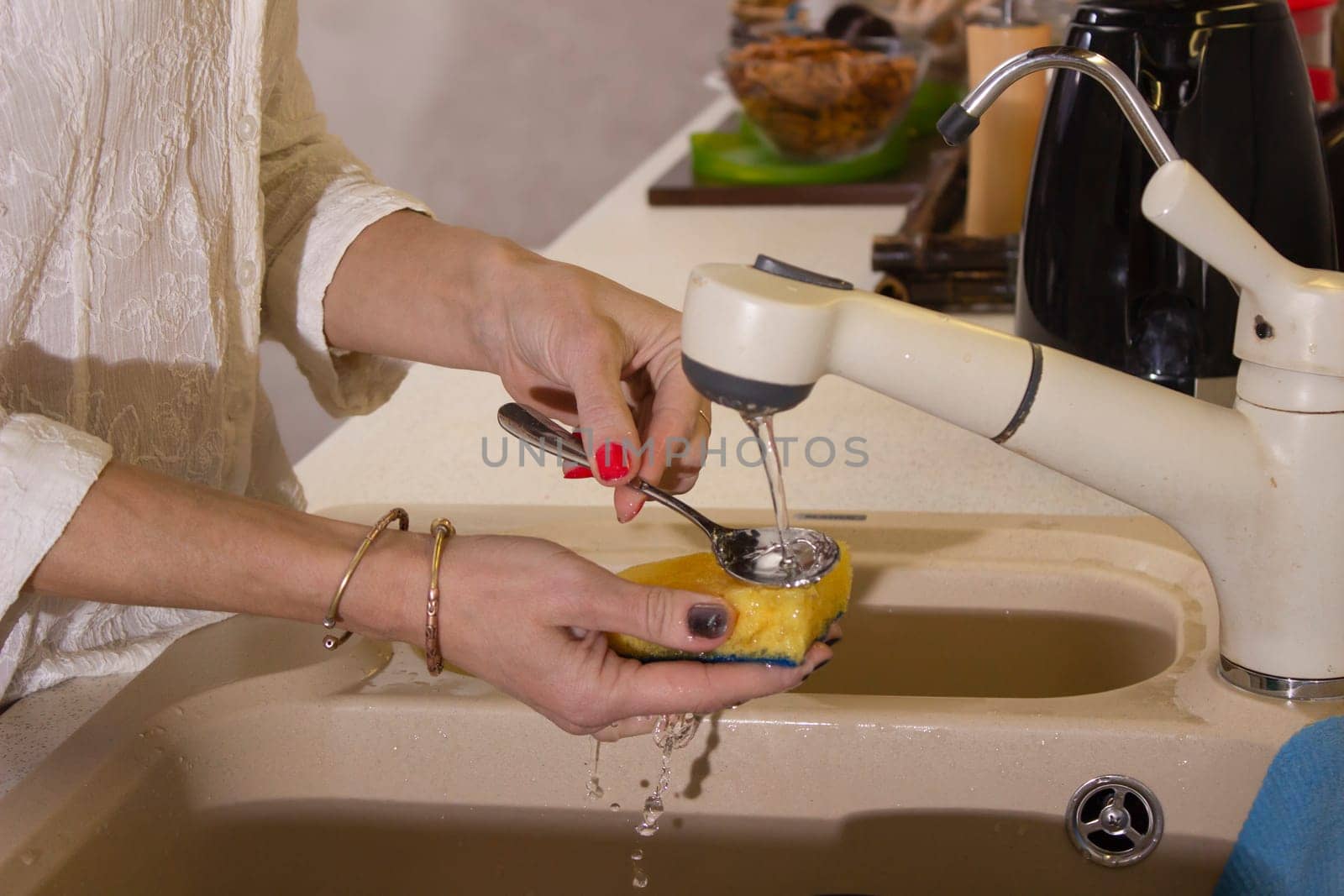 Young girl washing dishes on the kitchen, hands close up