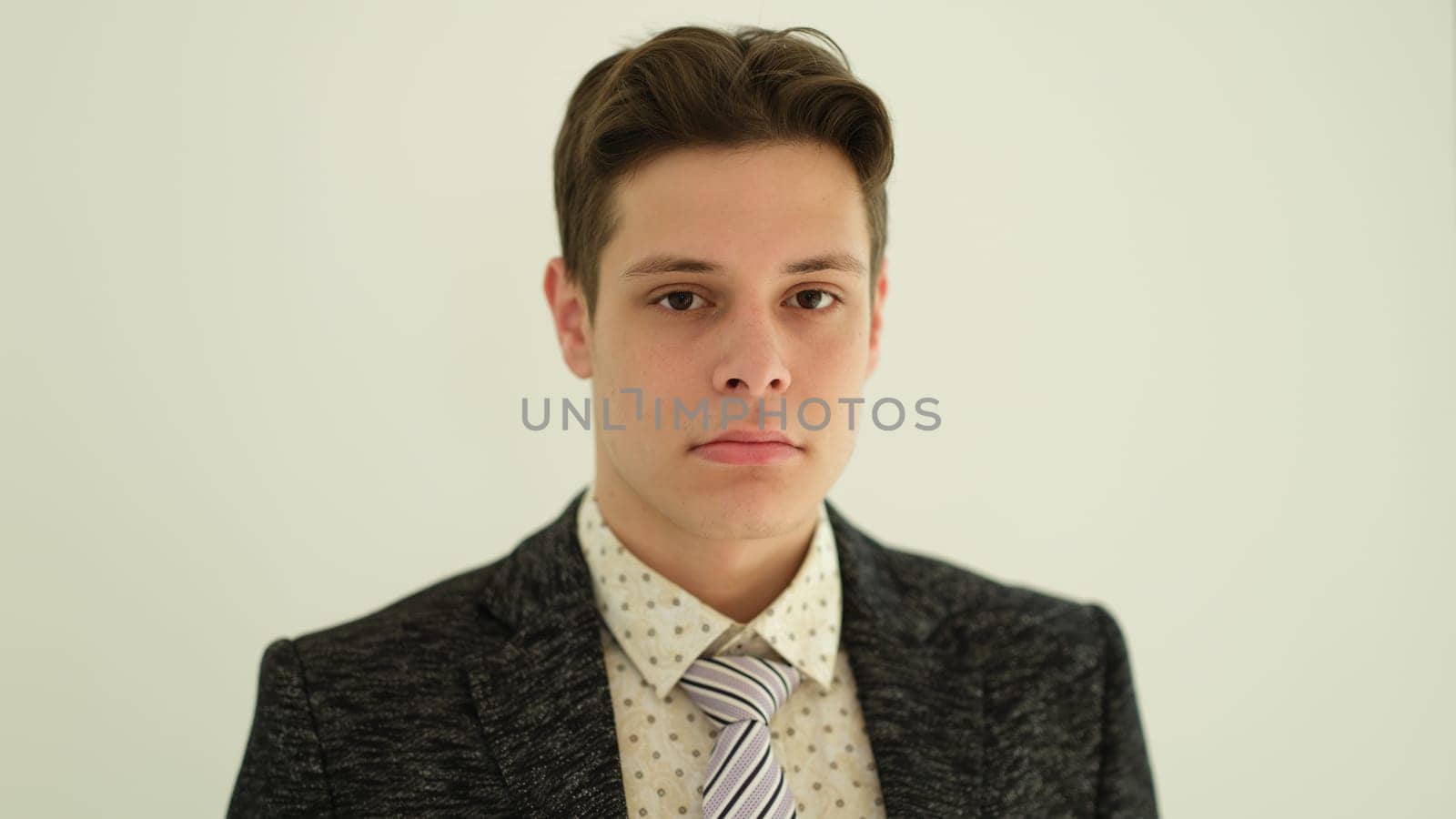 Portrait of young handsome businessman in suit with tie on white background. Career in business concept