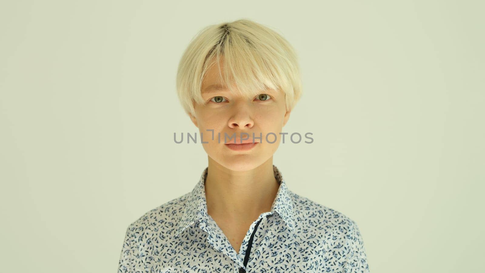 Portrait of young blonde woman with short haircut in shirt on white background. Stylish female hairstyles concept