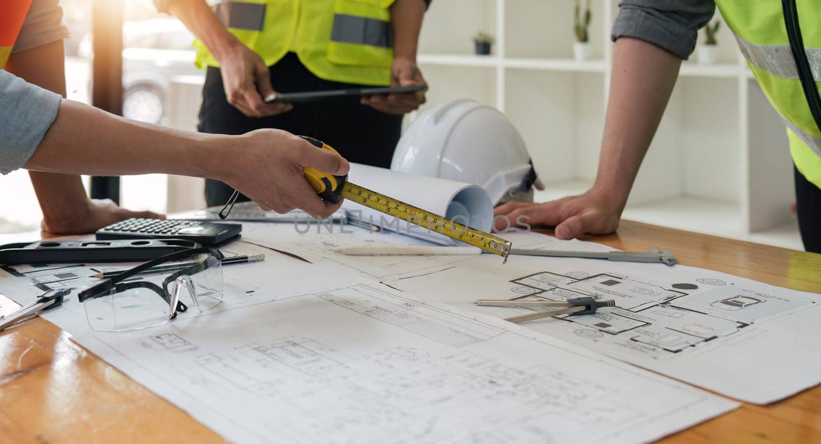 engineer people meeting working and pointing at a blueprint in office for discussing. Engineering tools and construction concept.