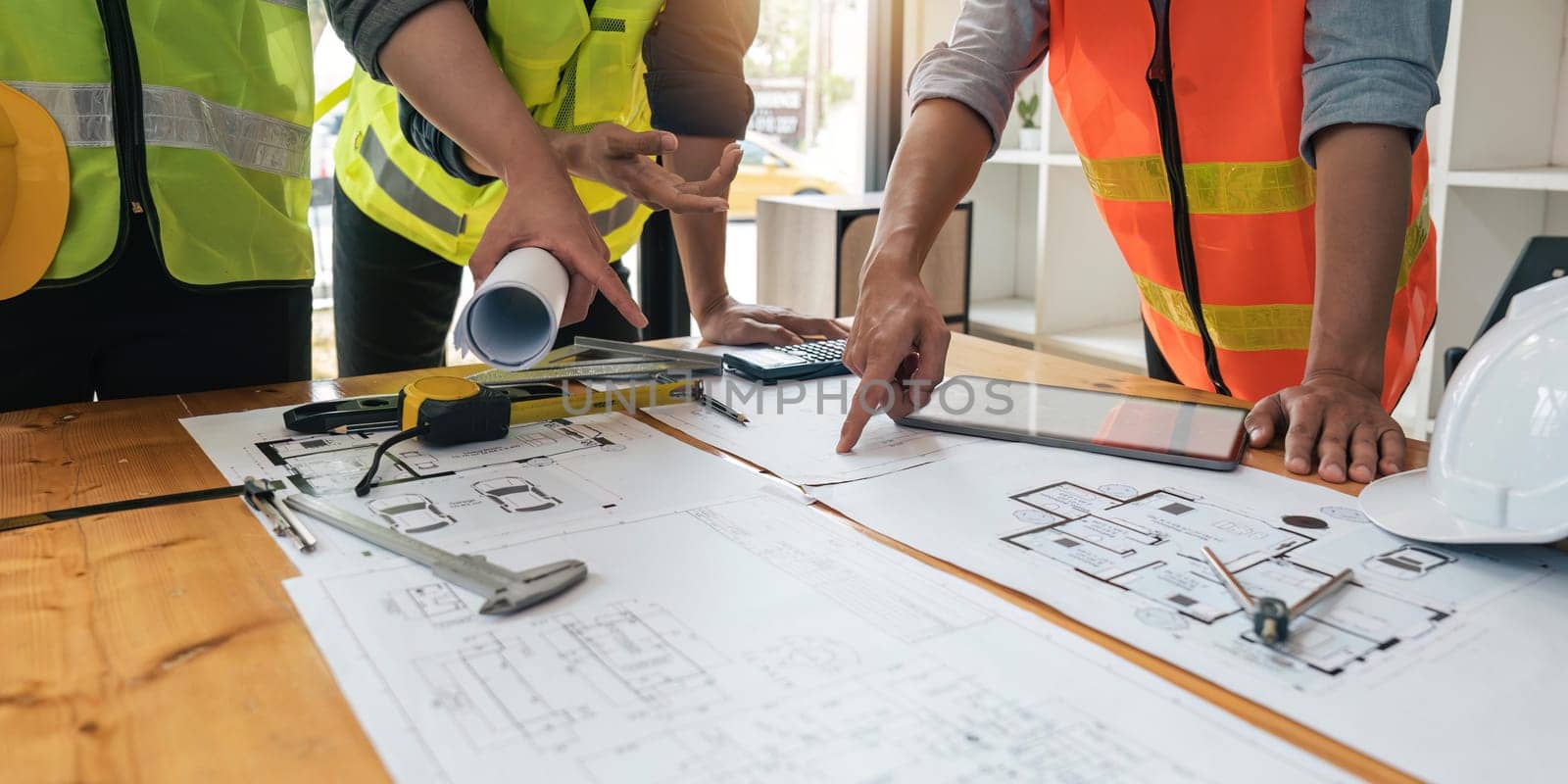 engineer people meeting working and pointing at a blueprint in office for discussing. Engineering tools and construction concept.