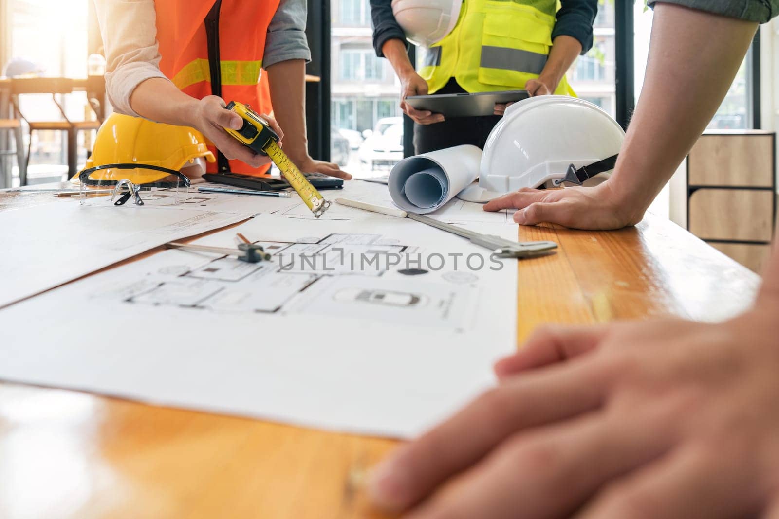 engineer people meeting working and pointing at a blueprint in office for discussing. Engineering tools and construction concept.