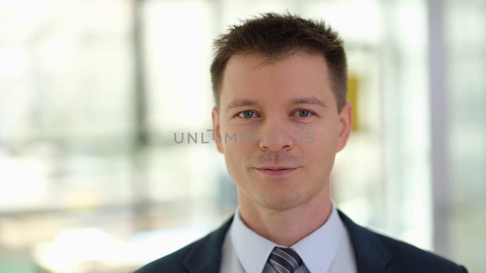 Portrait of young handsome businessman in suit with tie in office. Business career concept