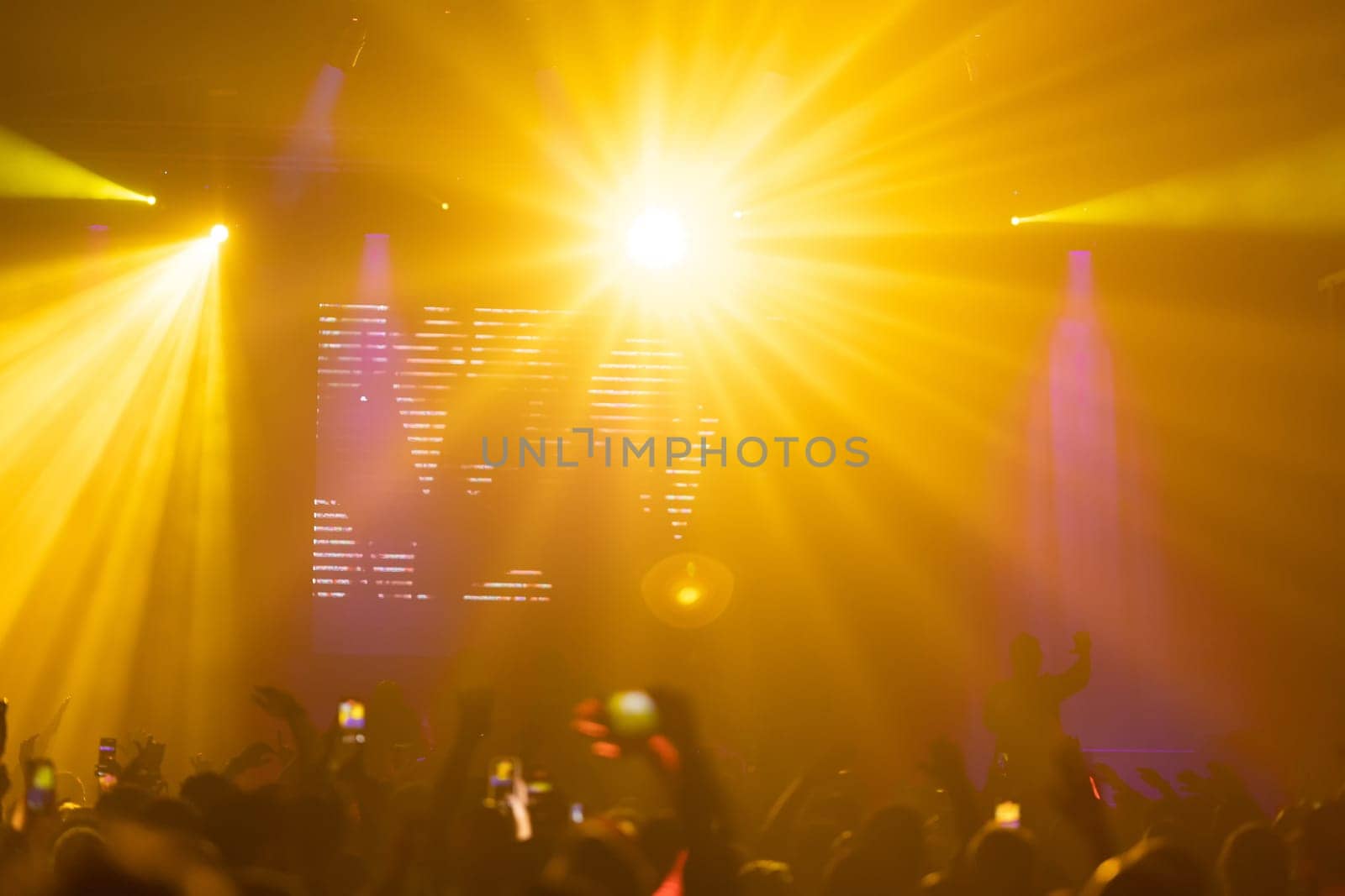 Bright yellow light illuminating the stage at a concert. Mid shot