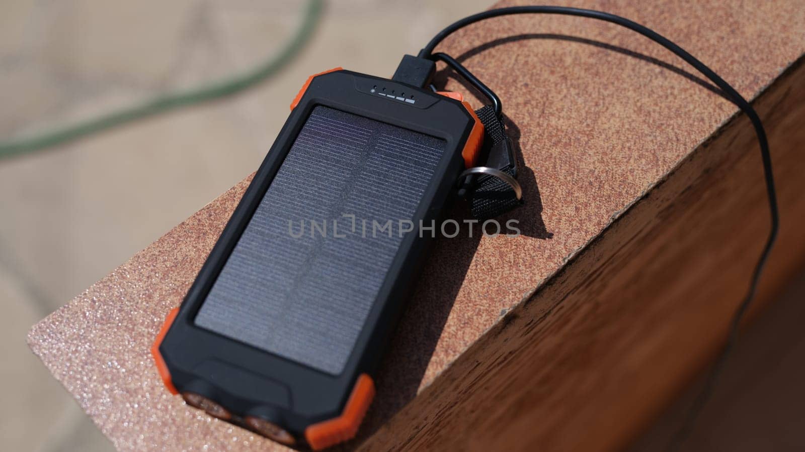 Solar charger lying outside and charging under sun rays closeup. Ecological modern technology concept