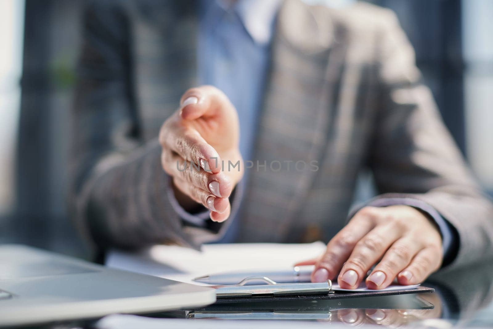 Caucasian middle aged man, personnel manager at the table making a welcome gesture